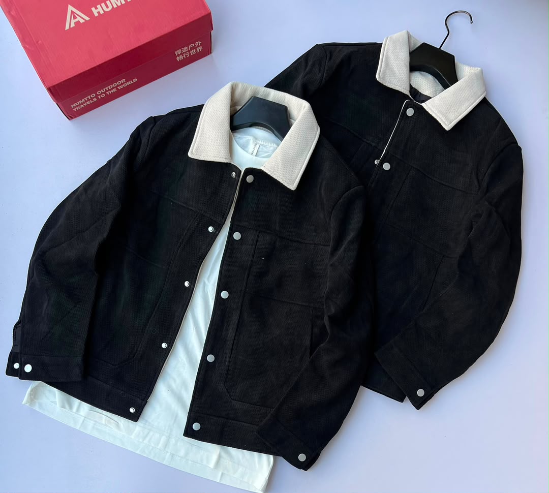 The HUMTTO Men's Corduroy Jacket with Contrast Collar is a casual, snap-button workwear jacket crafted from textured corduroy. It features a contrasting cream collar, front snap closure, chest stitch detailing, and side entry pockets.
