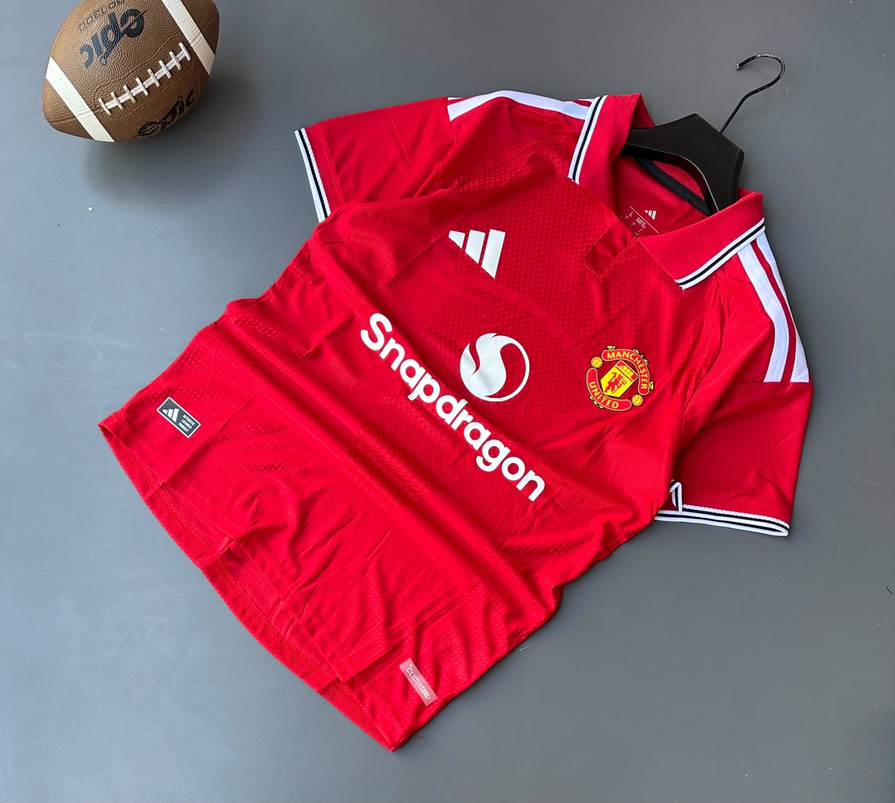 Manchester United team crest, embroidered Adidas logo, and heat-applied front sponsor logo
